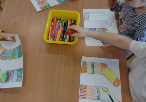 Czworo dzieci z grupy V kolorują papierowe skarpetki