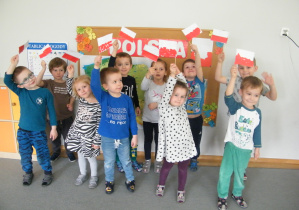 Dzieci z grupy II wymachują flagami biało-czerwonymi