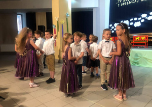 Dzieci stoją po kole w parach, przygotowane do tańca angielskiego