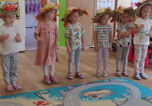 Sześć dziewczynek z grup I, II i III tańczą do piosenki o jesieni ubrane w kapelusze ozdobione liśćmi