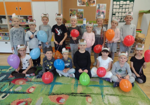 Dzieci z grupy Myszki pozują do zdjęcia z kolorowymi balonami