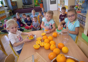 Trzy dziewczynki wyciskają sok z pomarańczy