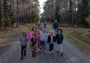 Dzieci idą leśną ścieżką