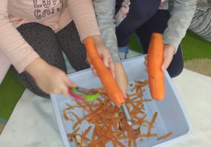 Dwie dziewczynki obierają marchewki