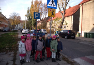 Przedszkolaki z grupy V stoją przy znaku "Przejście dla pieszych"
