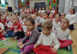 Przedszkolaki siedzą na dywanie i śpiewają refren piosenki o Polsce