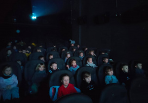 Dzieci z grupy II i III oglądają w kinie bajkę