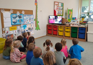 Dzieci oglądają film edukacyjny o bezpiecznych zabawach na śniegu