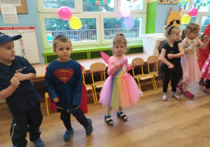 Pięcioro dzieci w przebraniach tańczy do muzyki