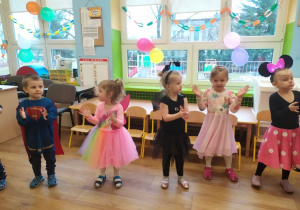 Pięcioro dzieci w przebraniach tańczy do muzyki