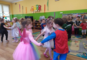 Przedszkolaki tańczą w małych kółeczkach