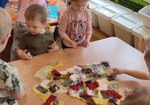 Pięcioro dzieci wykleja sukienkę skrawkami materiału