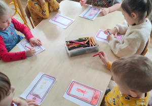 Sześcioro dzieci z grupy II koloruje papierowe tablety