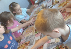 Przedszkolaki wybierają składniki na swoje pizze