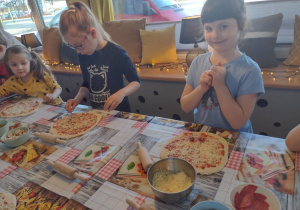Trzy dziewczynki wybierają składniki na swoje pizze
