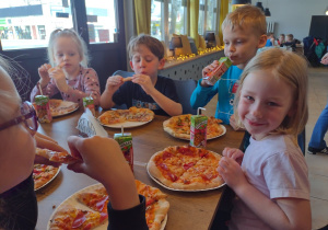 Pięcioro dzieci je wykonane przez siebie pizze