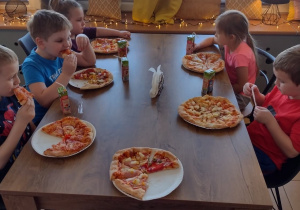 Piątka dzieci przygotowane przez siebie pizze