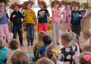 Siedmioro dzieci z grupy piątej tańczy w kapeluszach z kolorowymi liśćmi