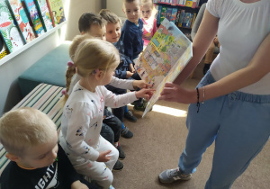 Dzieci z grupy pierwszej oglądają książeczkę