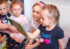 Czworo dzieci z grupy drugiej oglądają książeczkę sensoryczną