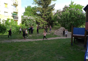 Przedszkolaki z grupy V biegają po ogrodzie przedszkolnym