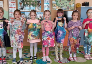 Siedem dziewczynek pokazuje swoje torby zabarwione farbami