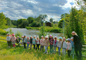 Przedszkolaki stoją przy rzece Warta