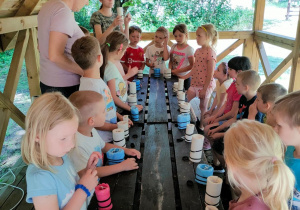 Dzieci wykonują świeczki podczas warsztatów o pszczółach i miodach