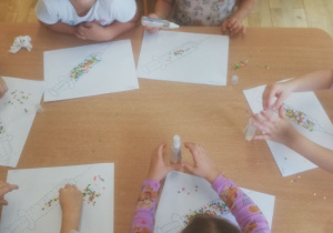 Praca plastyczna dzieci z grupy III - narysowane strzykawki z kolorowymi wirusami - konfetti