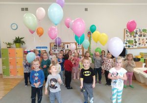 Dzieci z grupy drugiej stoją z balonami z helem podarowanymi przez rodziców