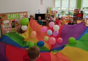 Dzieci z grupy trzeciej bawią się balonami i chustą animacyjną