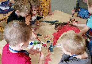 Chłopcy z grupy trzeciej malują farbami przedszkolaka