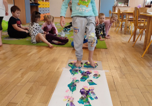 Dzieci z grupy czwartej wykonują obraz malując stopami