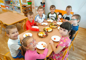 Ośmioro dzieci przygotowuje owocowe szaszłyki