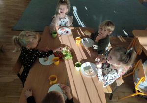 Pięcioro dzieci z grupy trzeciej je kanapki przygotowane przez siebie