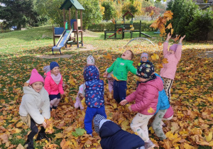 Przedszkolaki z grupy trzeciej rzucają się liśćmi