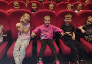 Dziewięcioro dzieci siedzi w fotelach czekając na przedsatwienie