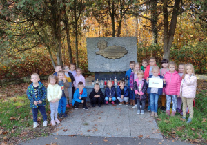 Dzieci z grupy V ustawione są przy pomniku żołnierzy