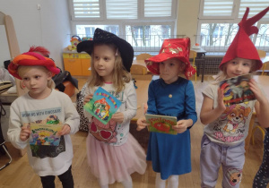 Cztery dziewczynki trzymaja książeczki do piosenki