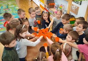 Dzieci z grupy piątek wznoszą toast koktajlem owocowo-mlecznym