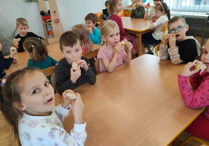 Dzieci z grupy piątej jedzą upieczony przez siebie chleb