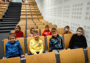 Ośmioro dzieci z przedszkola siedzą na widowni przed spektaklem