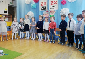 Dzieci stoją podczas spiewania piosenki