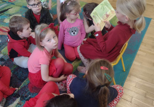 Dziewczynka czyta dzieciom książeczkę