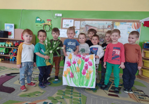 Chłopcy z grupy pierwszej z laurką i kwiatami dla dziewczynek