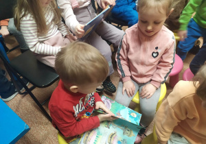 Dwoje dzieci ogląda książeczkę