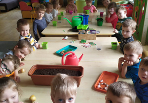 Dzieci przy stolikach z doniczkami