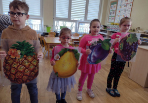 Chłopiec i trzy dziewczynki ze zdjęciami owoców