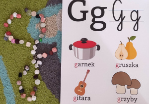 Mała literka "g" ułożona z guzików przez dzieci