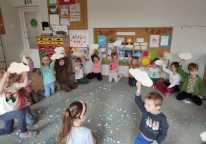 Dzieci pokazują wyciętę chmurki z papieru